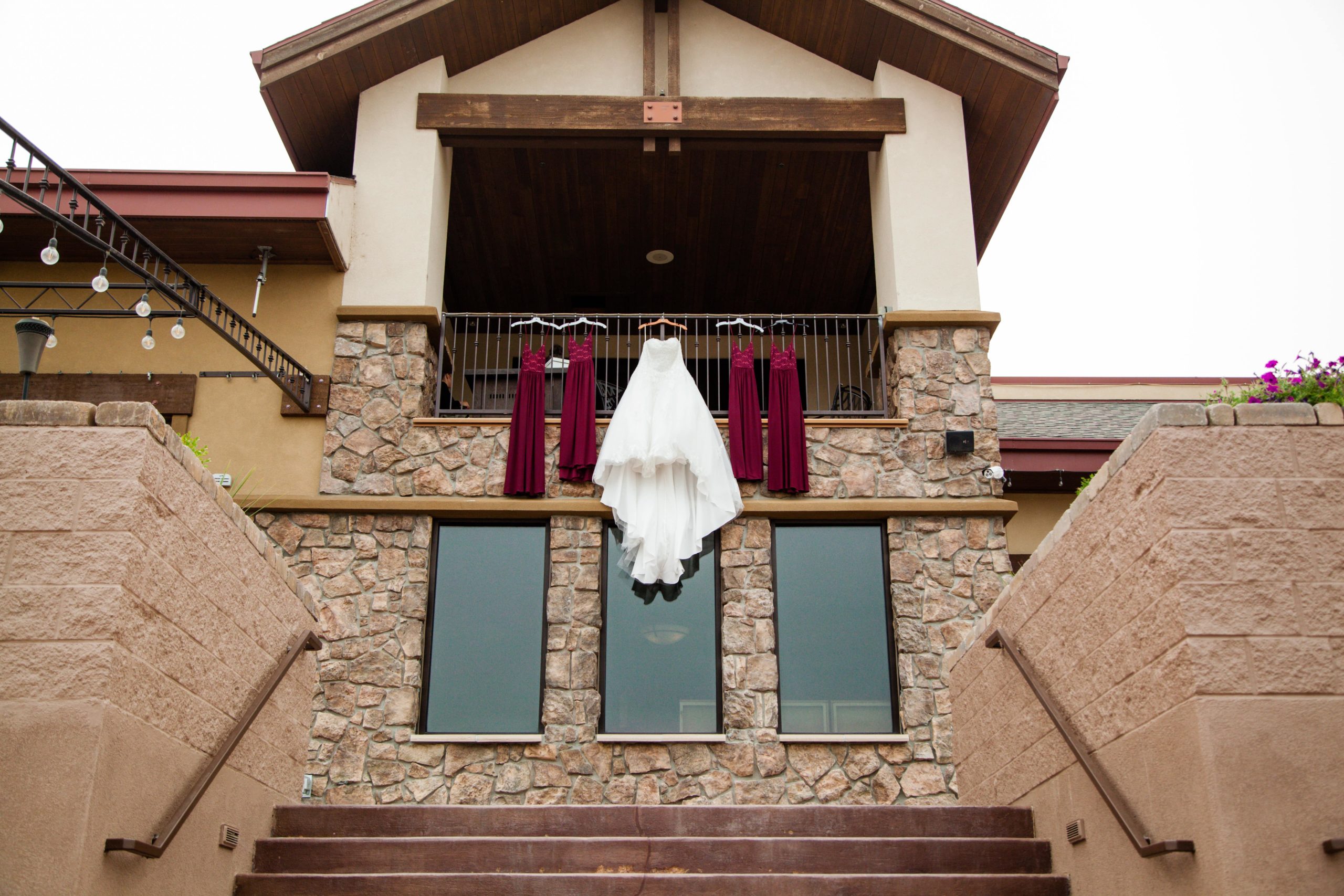 event venue with a wedding dress and bridesmaids dresses hanging on a balcony
